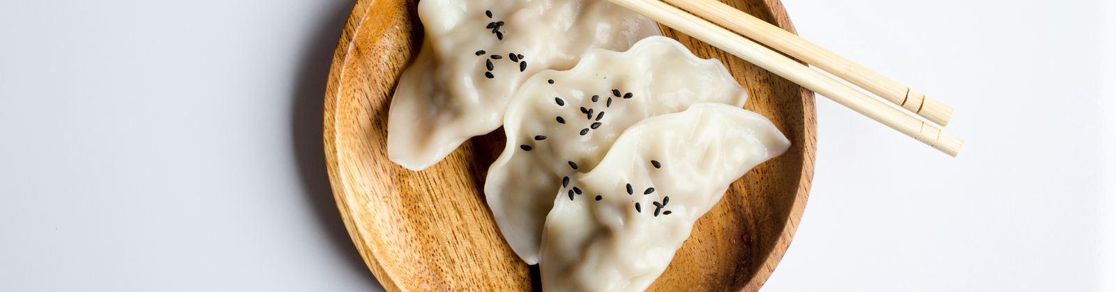 Dumplings and chopsticks in a wooden bowl