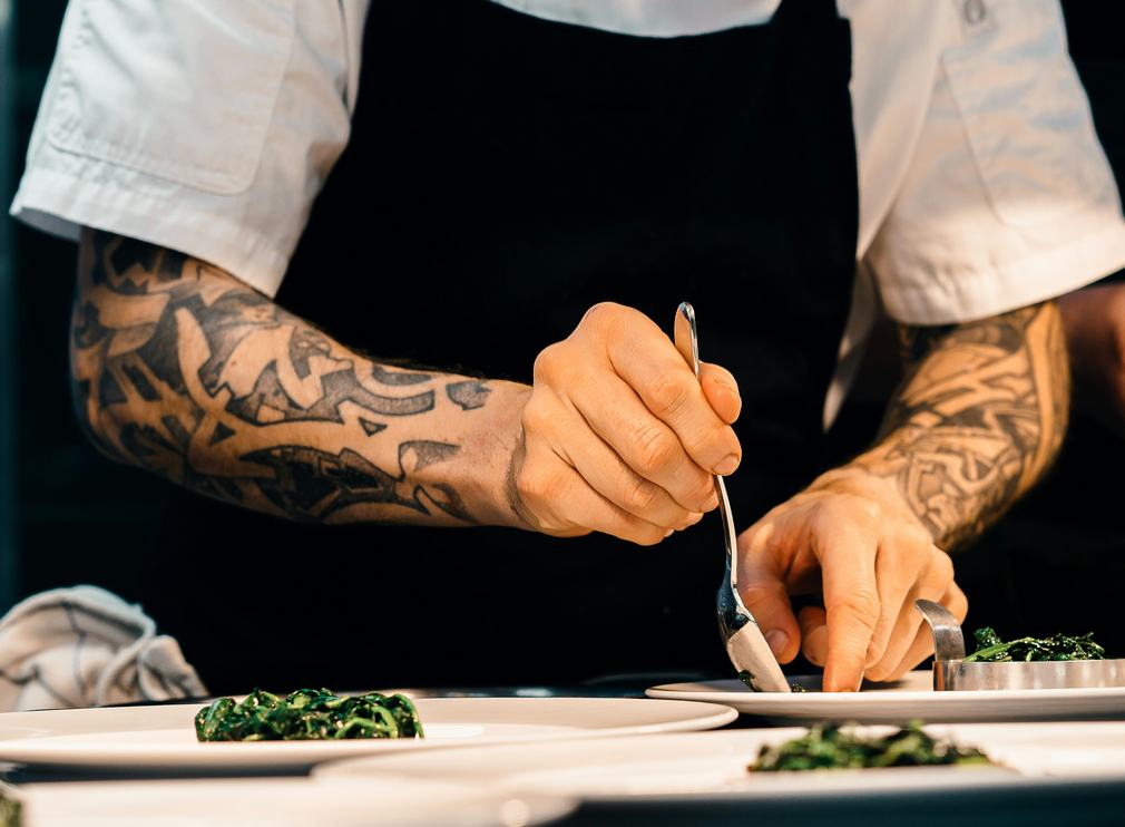 Chef plating a dish with tweezers