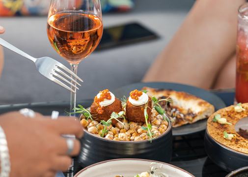 Shared dishes and wine on a restaurant terrace table