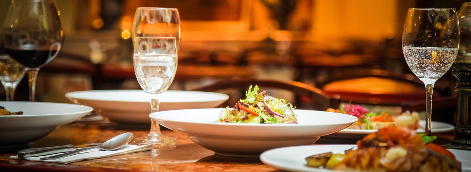 Restaurant table set with wine and dishes in warm light
