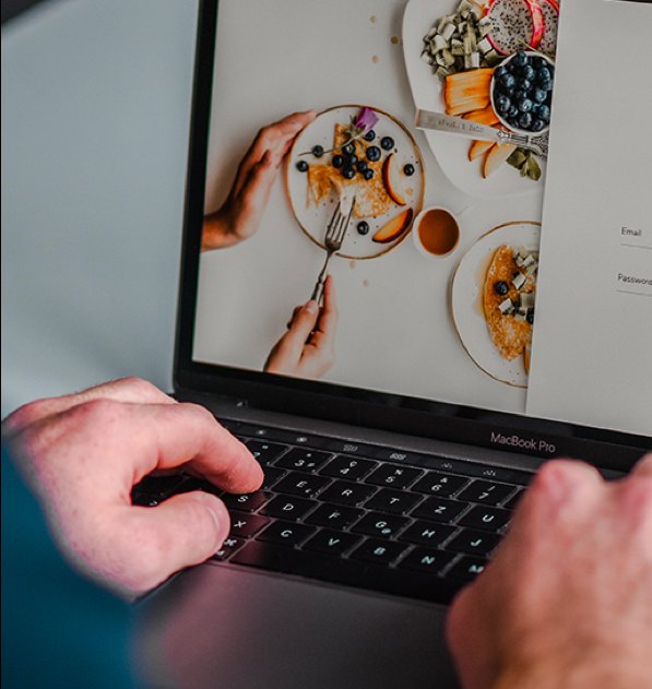 Hands on a laptop keyboard with a restaurant menu on screen
